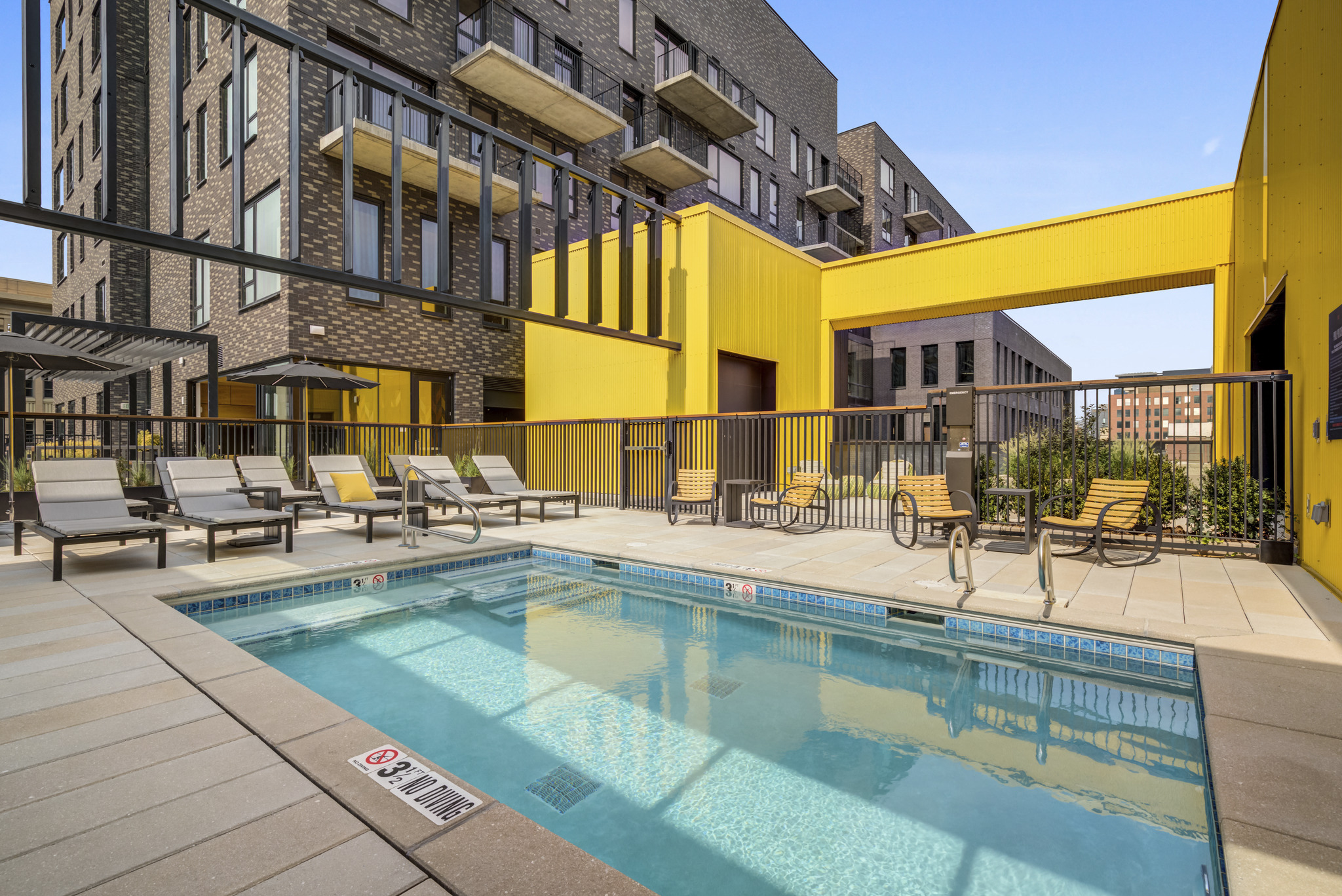 the pool area of a building with a swimming pool and lounge chairs