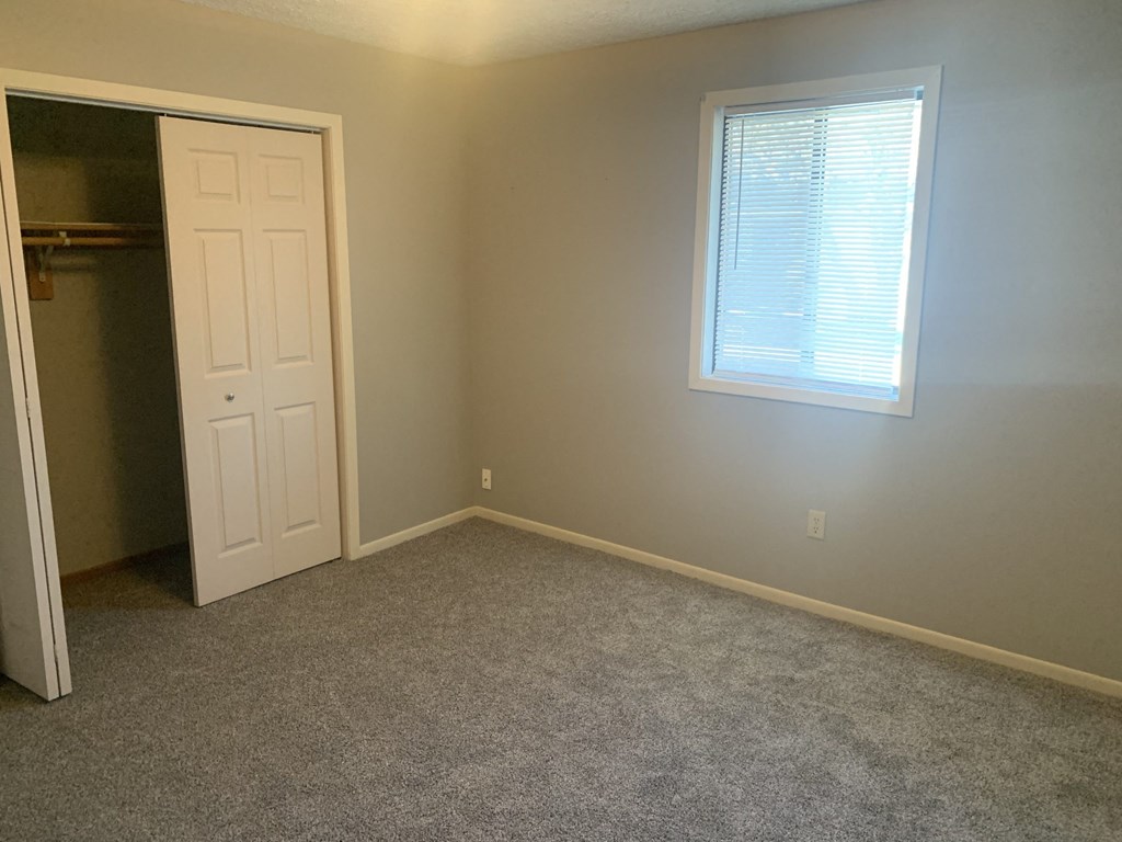 a room with a closet and a window and a door