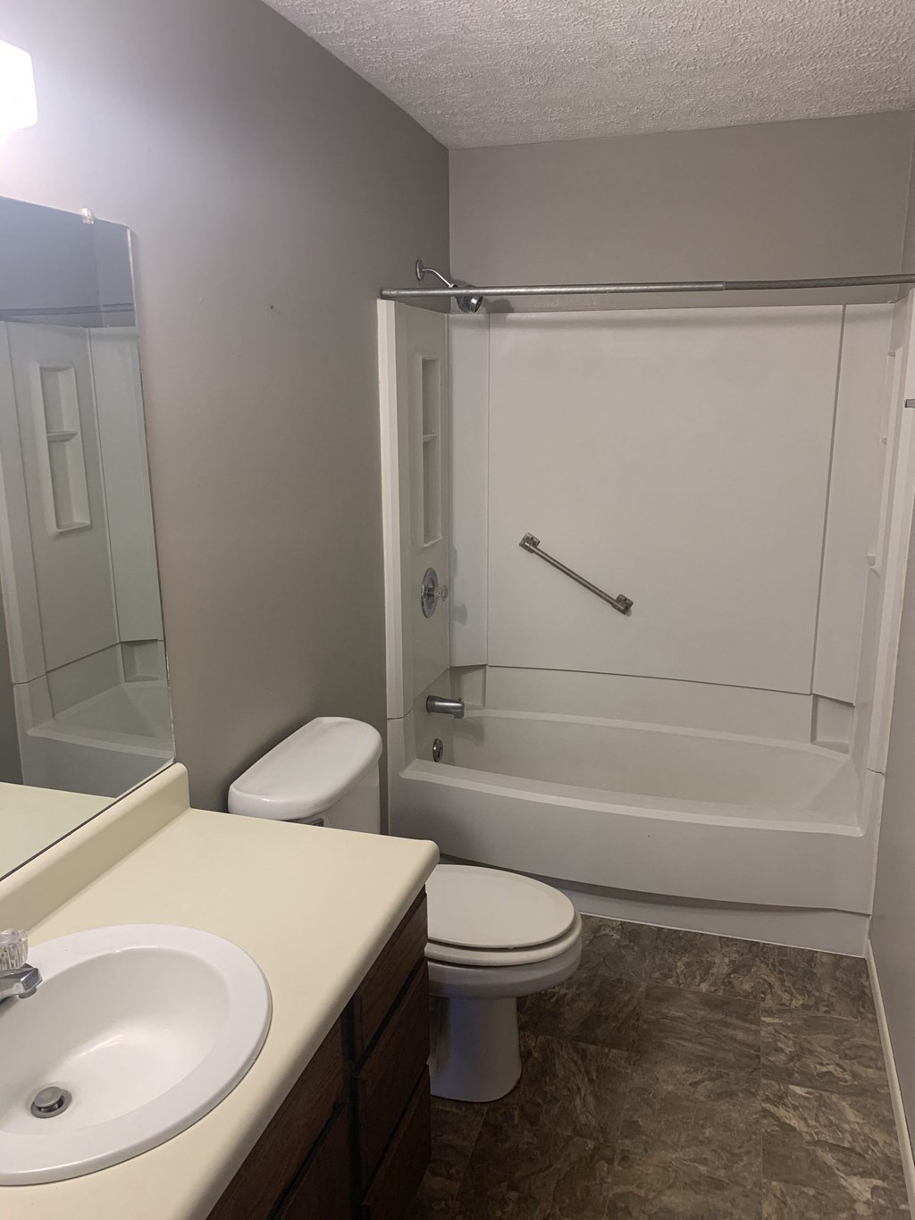 an empty bathroom with a shower toilet and sink