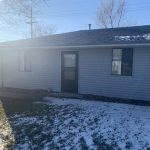a white house with a yard covered in snow