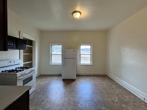 A kitchen with a stove top oven and a refrigerator.