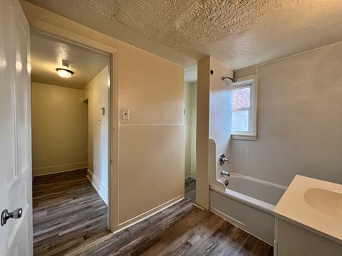 A bathroom with a white sink and a window.