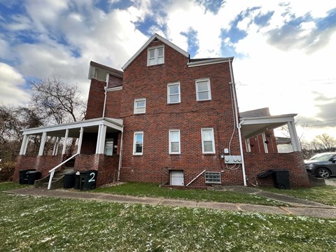 A red brick house with a white door and windows.