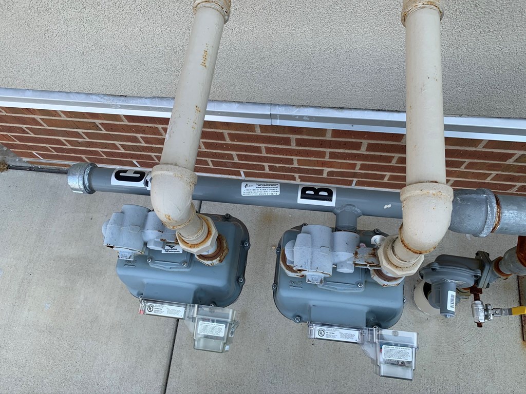 two pipes are connected to a brick wall