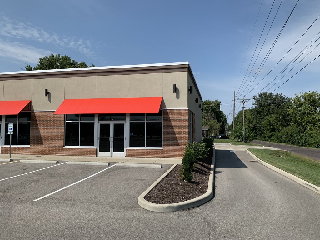 an office building with a red roof and a parking lot