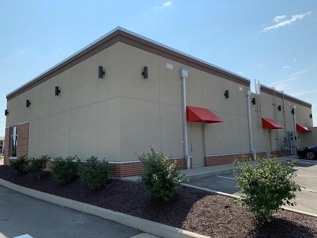 the side of a building with red umbrellas