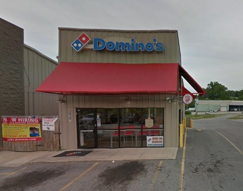 A Domino's Pizza store with a red awning and a hiring sign.
