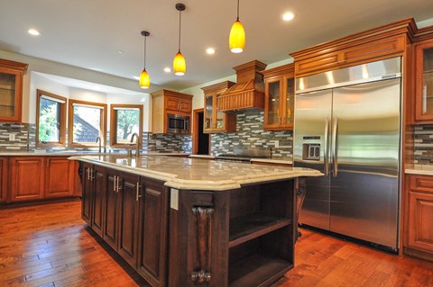 A kitchen with wooden cabinets and a marble countertop.