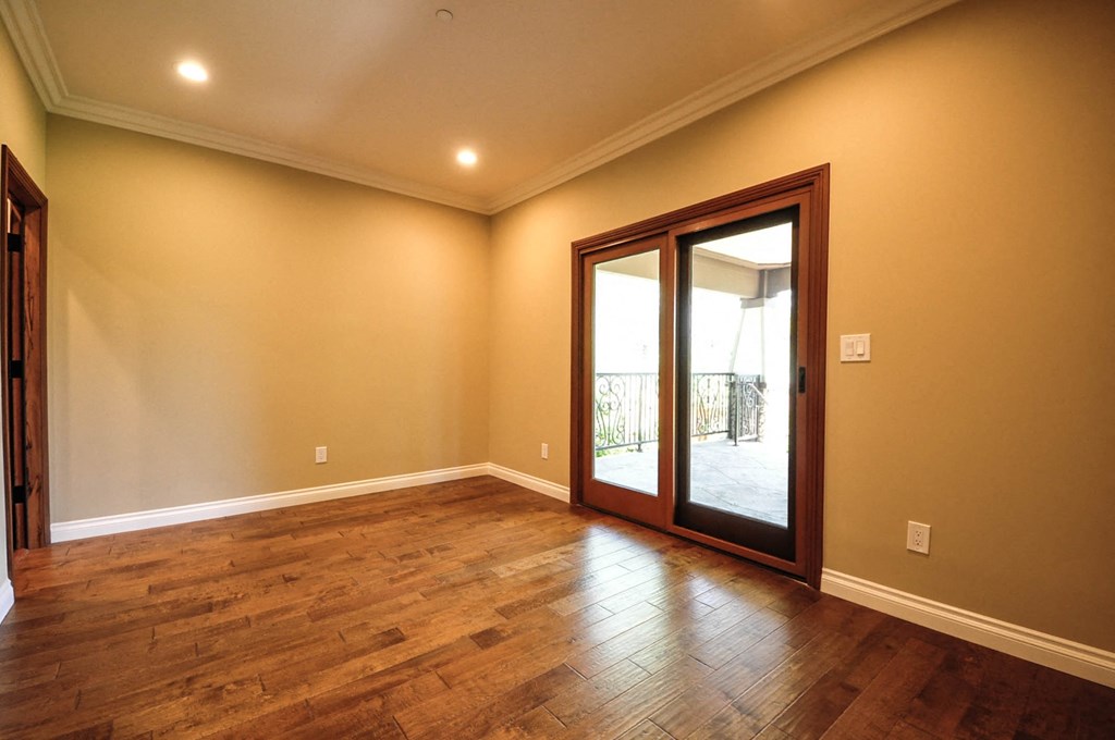 A room with wooden floors and a sliding glass door.
