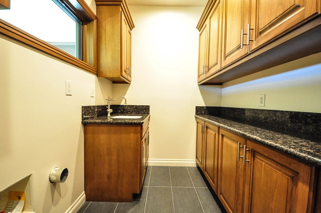 A kitchen with wooden cabinets and a granite countertop.
