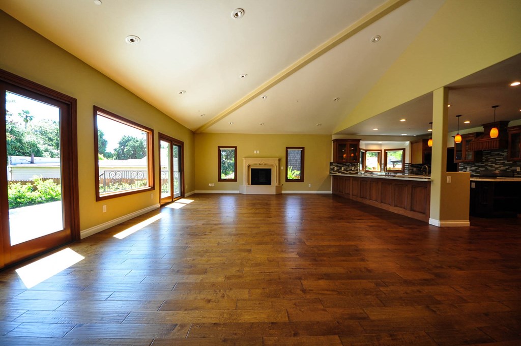 A large room with wooden floors and a bar area.