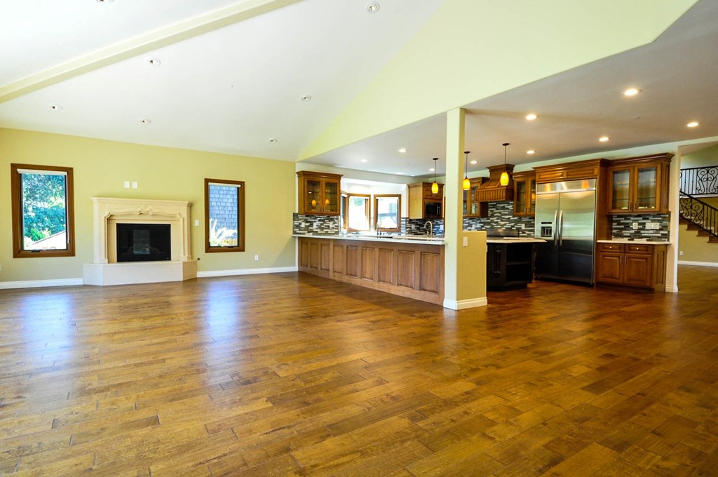 A spacious living room with a fireplace and hardwood floors.