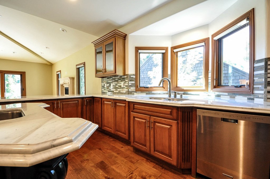 A kitchen with wooden cabinets and a stainless steel dishwasher.