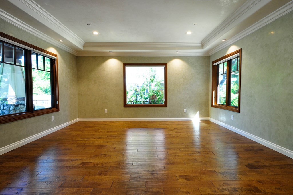 A room with wooden floors and windows on both sides.