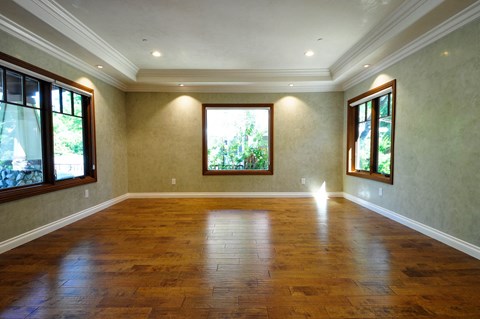 A room with wooden floors and windows on both sides.