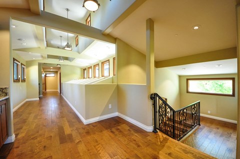 A large open living space with wood floors and a staircase.