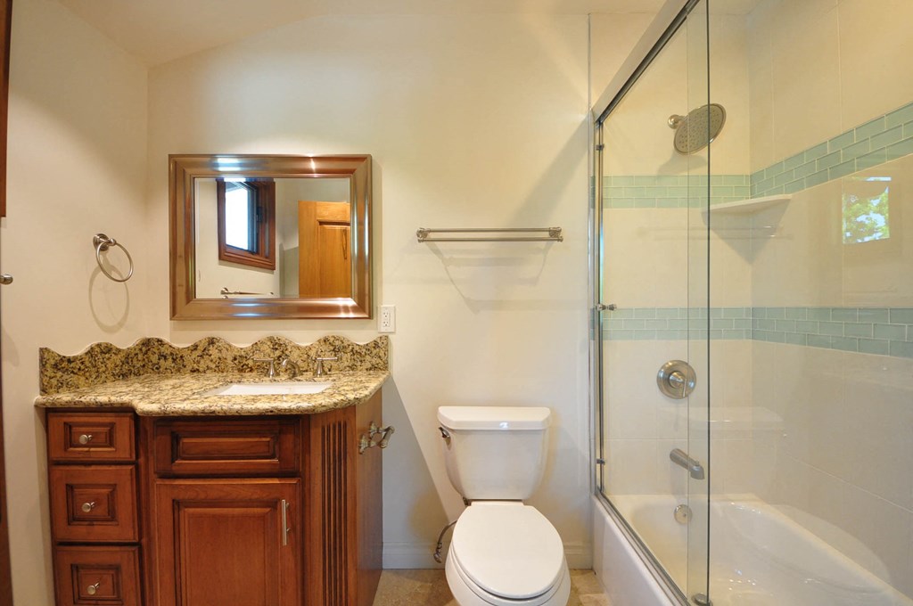 A bathroom with a toilet, sink, and shower.