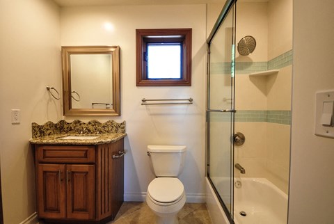 A bathroom with a toilet, sink, and shower.