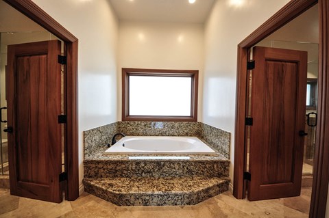 A bathroom with a marble countertop and a window.