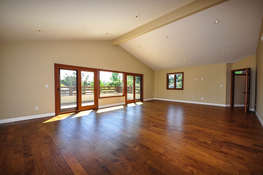 A spacious room with wooden floors and a skylight.