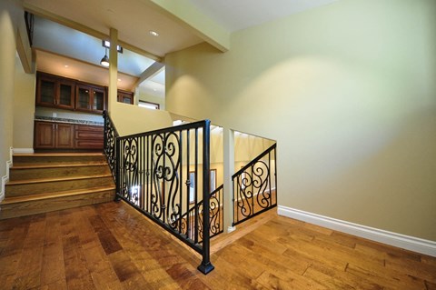 A staircase with a black wrought iron railing.