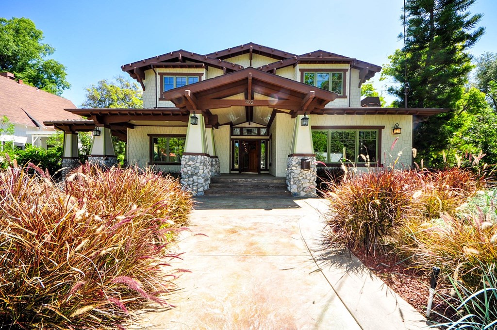 A house with a brown roof and a stone pillar in front.
