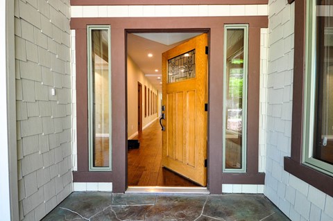 A wooden door is at the end of a hallway.