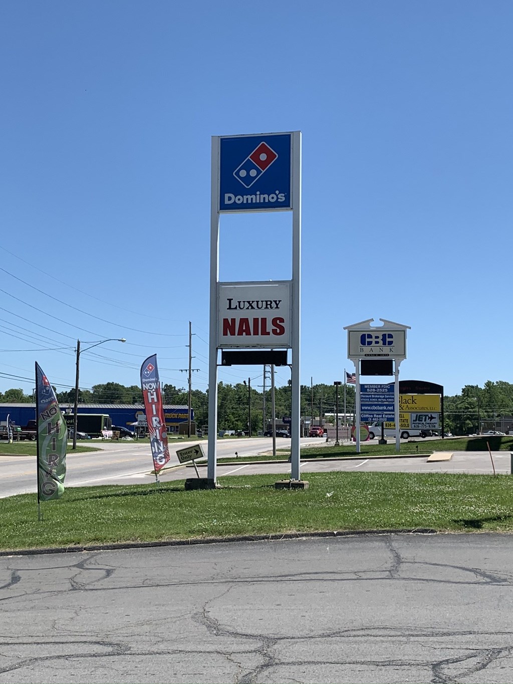 A Domino's pizza sign is in front of a nail salon.