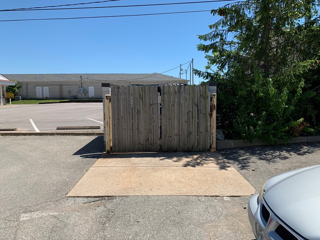A wooden gate blocks the entrance to a parking lot.