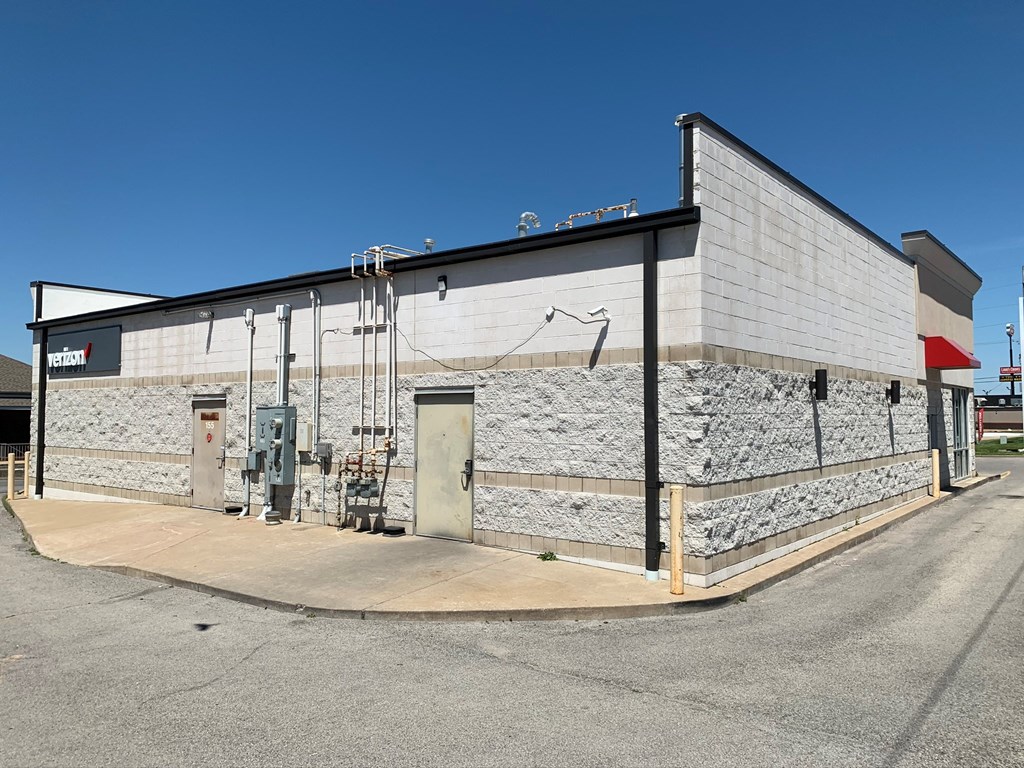 A large industrial building with a red sign on the left side.