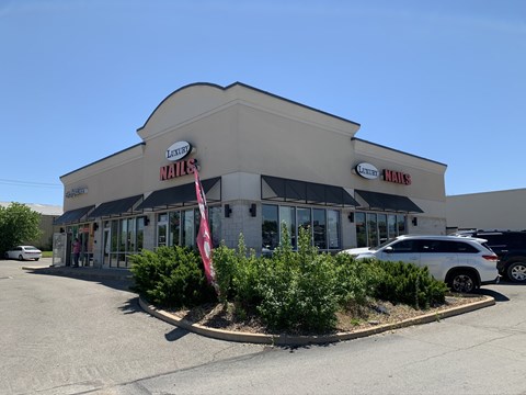 A nail salon with a sign that says "Luxe Nails" on the front.