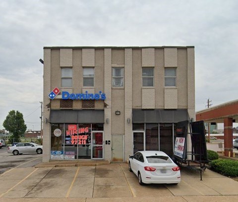 A white car is parked in front of a Donnie's store.