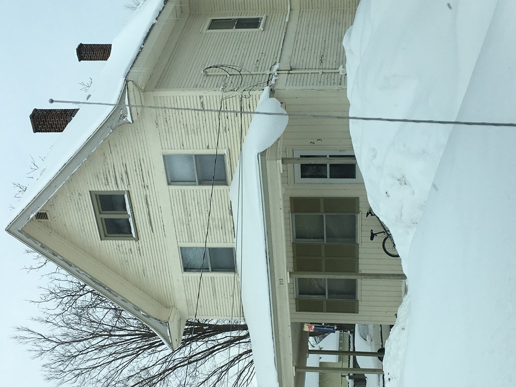 A house with snow on the roof and walls.