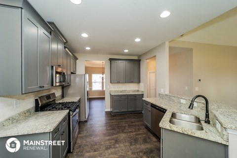 a large kitchen with granite counter tops and stainless steel appliances
