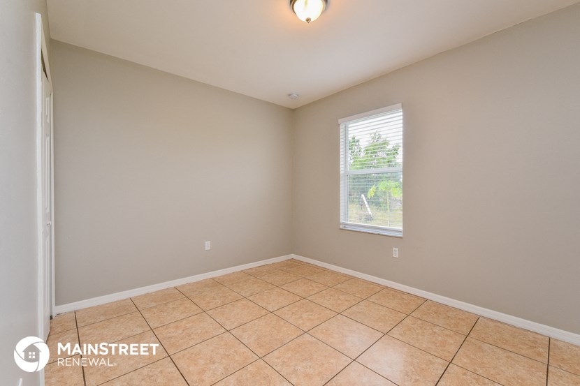 the spacious living room with tiled flooring and a window