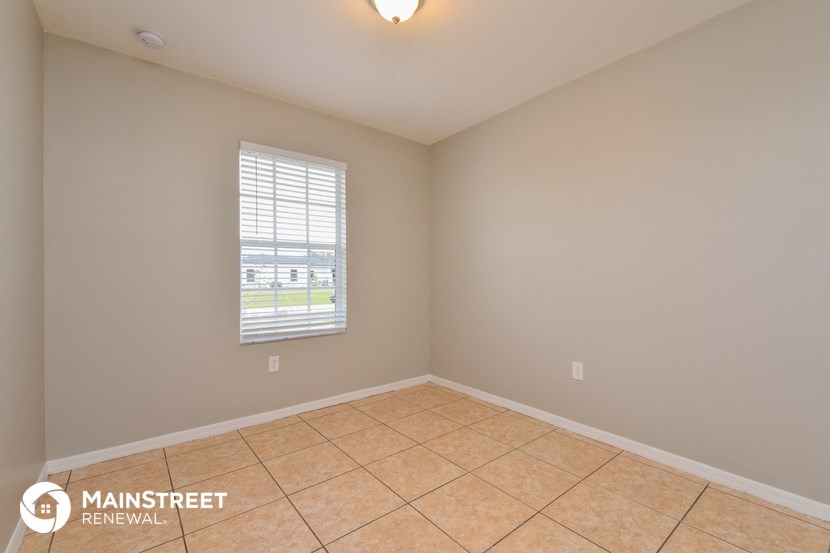 the spacious living room with tile flooring and a window