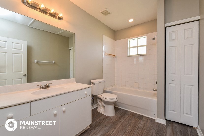 a bathroom with a toilet sink and tub and a mirror