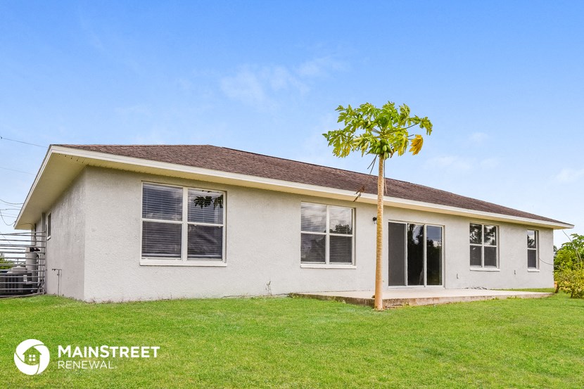 a small white house with a palm tree in front of it
