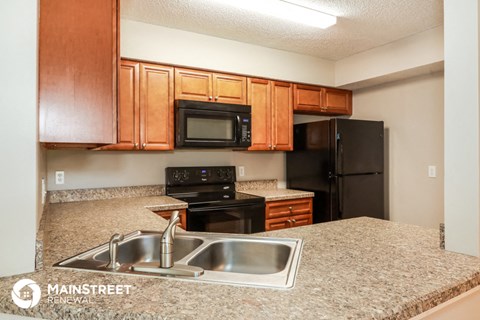a kitchen with granite counter tops and black appliances