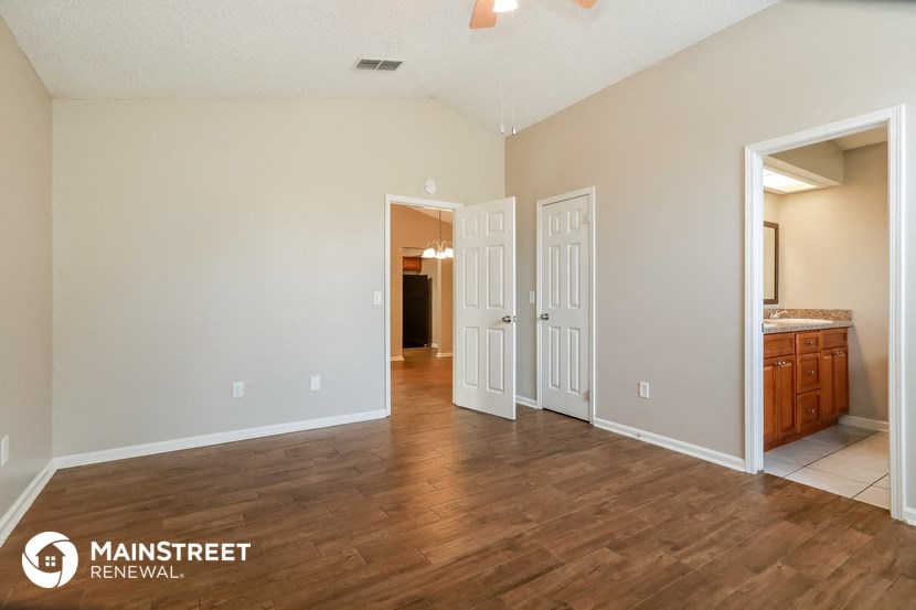 the living room and entrance into the master bedroom of this manufactured home