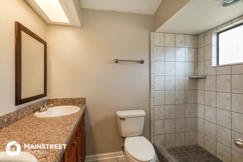a bathroom with a toilet and a sink and a shower