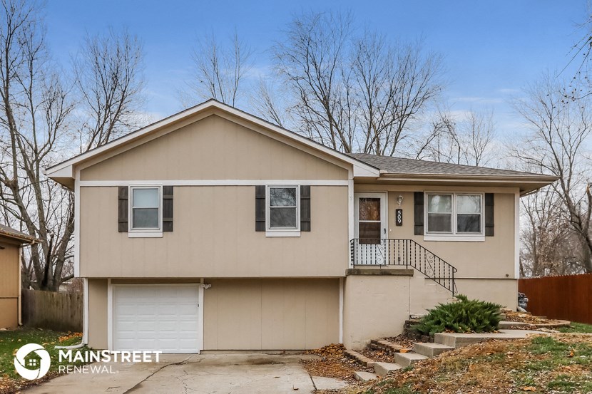 the exterior of a beige house with trees in the background