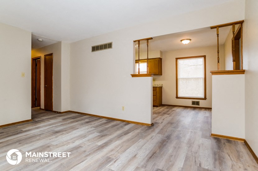 an empty living room with white walls and wood floors
