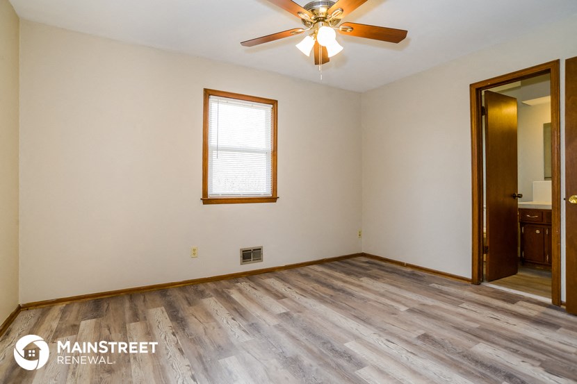 the living room of an empty house with wood floors and a ceiling fan