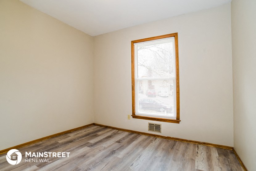 the living room of a home with wood floors and a window