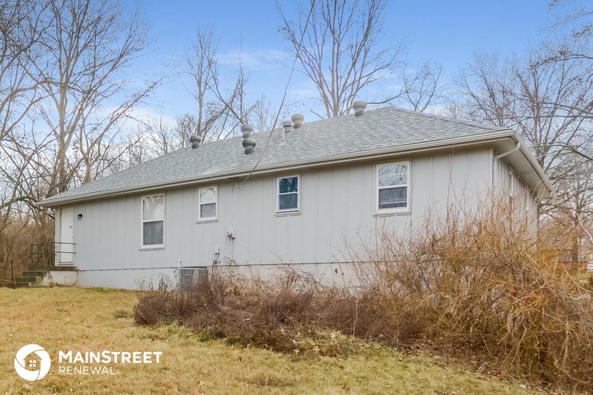 a white house with a gray roof in a field