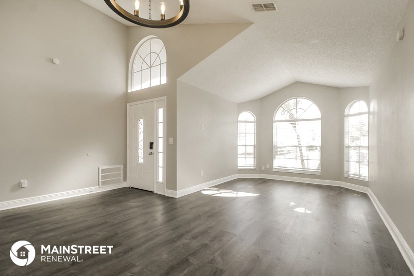an empty living room with white walls and wood floors