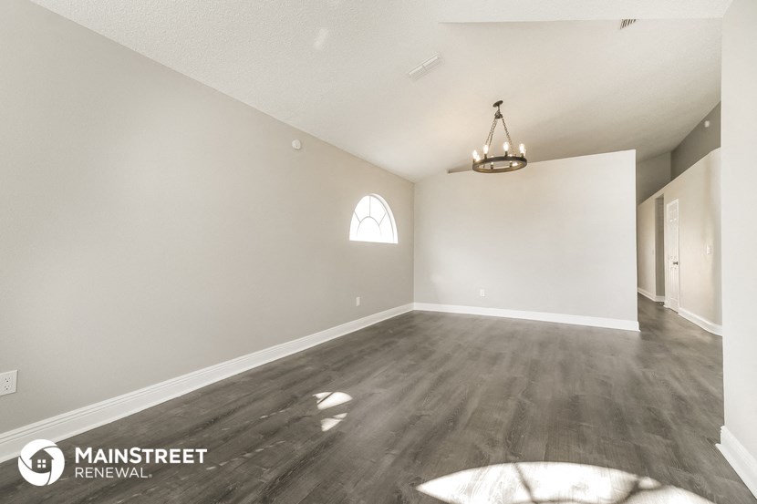 the living room and dining room of an empty house