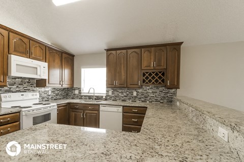 a kitchen with granite counter tops and wooden cabinets