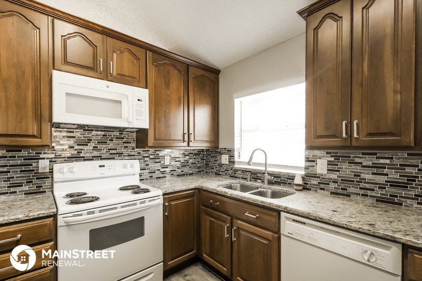 a kitchen with white appliances and wooden cabinets
